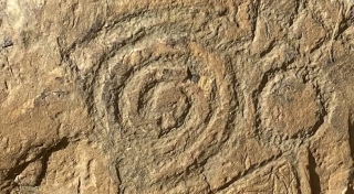 Carved Kerbstone depicting Spiral and Circle, Knowth, County Meath. Photo. Jay Hōdo Roche.