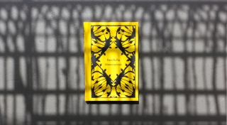 A yellow book reads 'Franz Kafka, Metamorphosis' and is decorated with a black pattern.