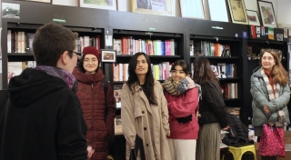 A group of people stand in conversation in a book shop