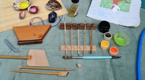 A photo of paints and paint brushes laid out on a table.