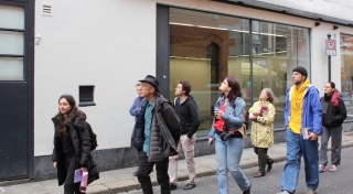 A group of people walk through Temple Bar as part of Art Walk