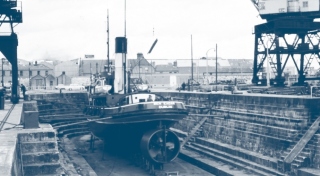 A blue halftone image of a large boat on a dry dock with an industrial crane at Dublin Port