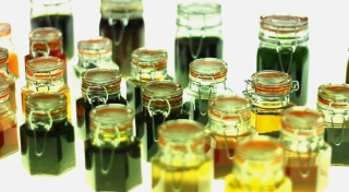 21 glass pickling jars of various size contain various coloured liquids.