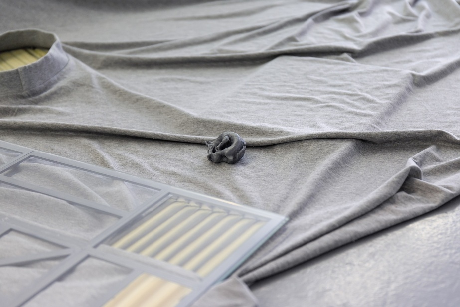 Commissioned Writer: Thomas Morris 'Good Boy'

Grey marle fabric, carved galalith from unused blank stock c.1940-50, CNC machine cut galalith sheets, microfaded galalith sheet, empty meal bags, metal, empty mineral lick bucket, straw, wood, 3D printed Viking ‘Fenrir’ wolf toggles and bog butter top surface (Corlea, Co.Monaghan), bucket handle, silage wrap, baler twine, 3D printed solar panel grid, plastic veterinary glove, magnesium bolus’, cast jesmonite, blown glass. Photo credit: Kasia Kaminska.